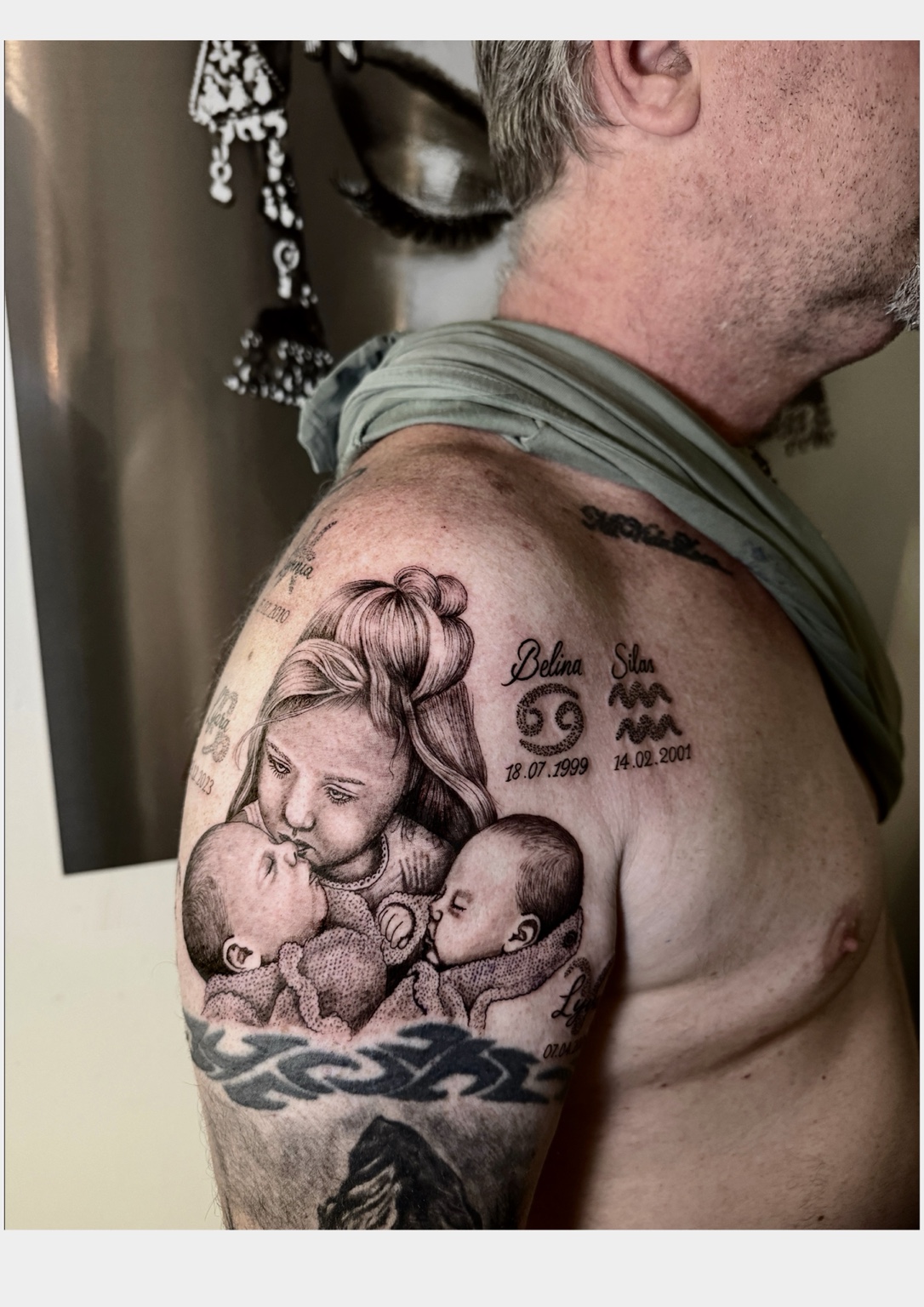 Black-and-grey family portrait tattoo on a shoulder